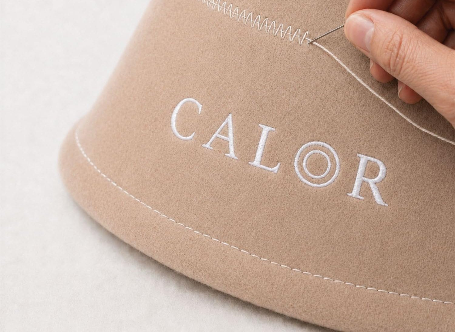 Close up of CALOR merino felt and embroidered logo